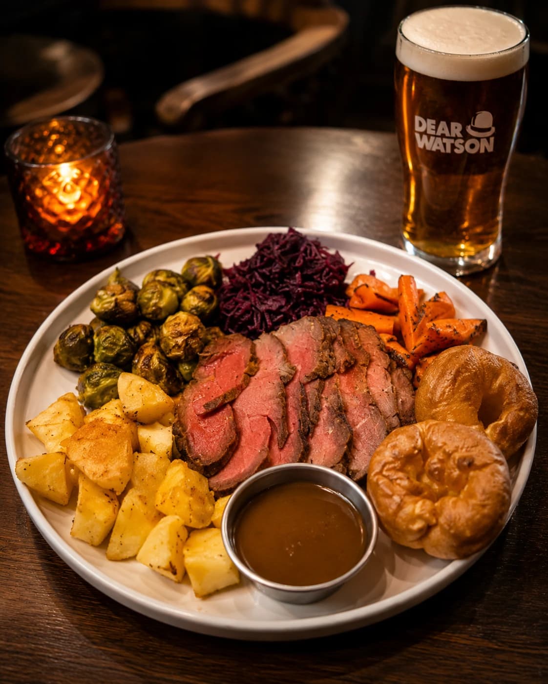 Dear Watson Sunday Roast plate beside a branded pint